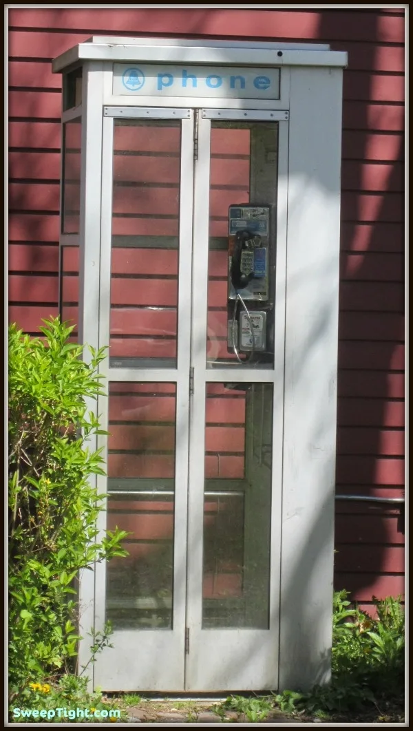 A phone booth with a payphone in it. 