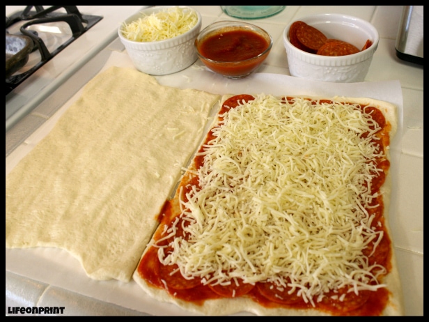 Pizza dough with sauce and cheese.