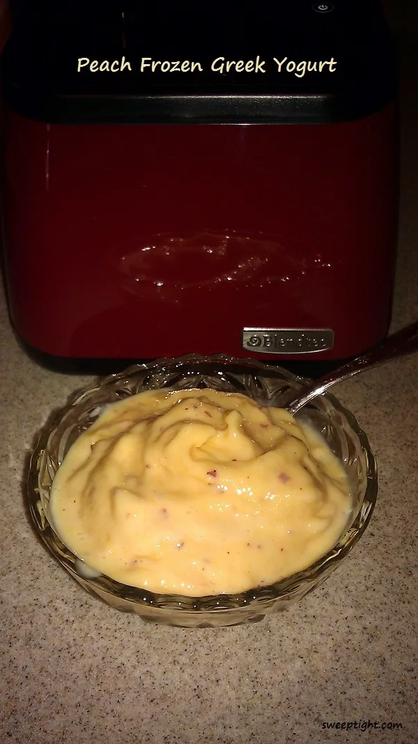 Peach Frozen Greek Yogurt in a bowl with a spoon.