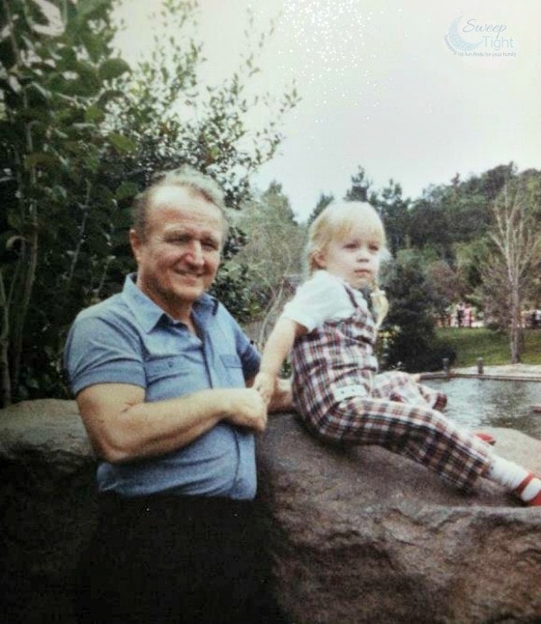 Me as a child sitting on a rock holding my grandfather's hand