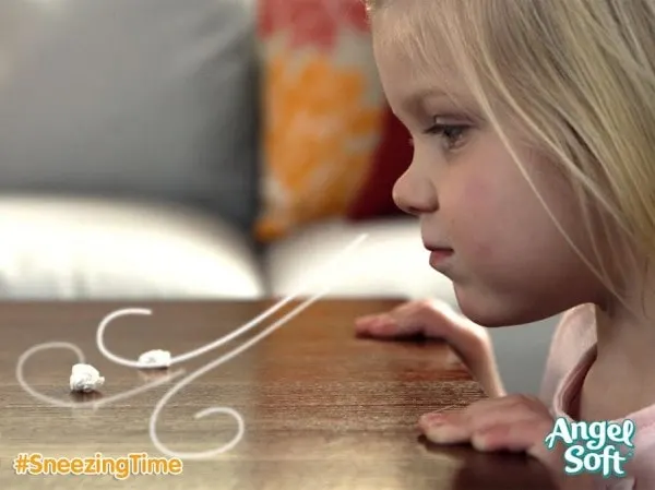 Little girl blowing her nose on the table. 