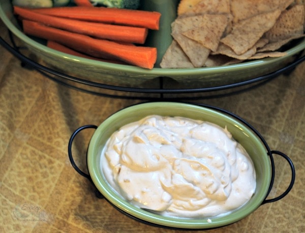 Onion dip next to carrots and chips for dipping. 