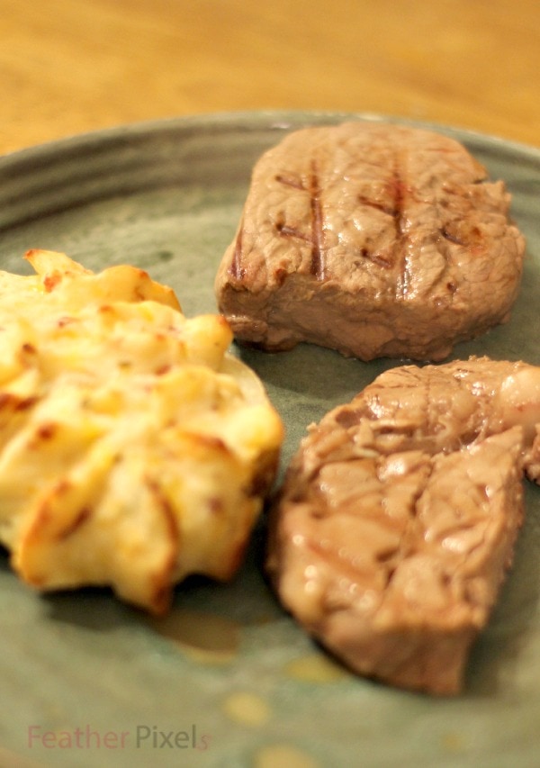 Steak and a double baked potato on a plate. 