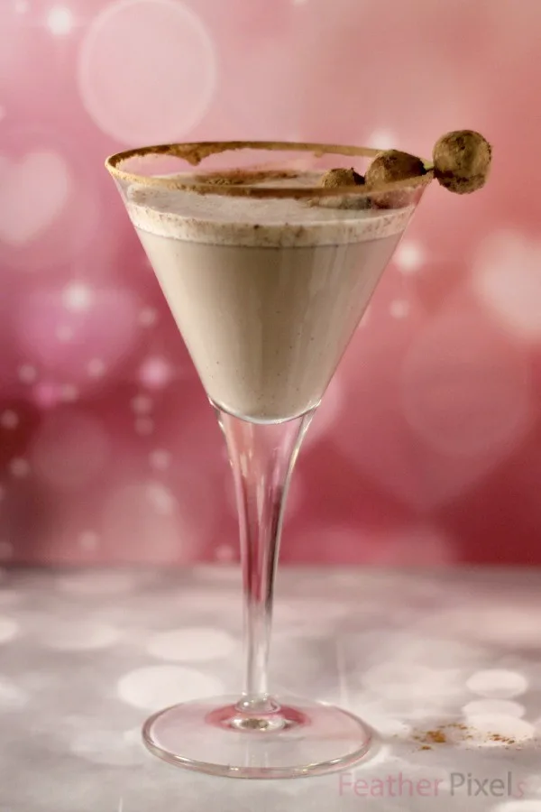 Snickerdoodle cookie martini in a glass with a pink background. 