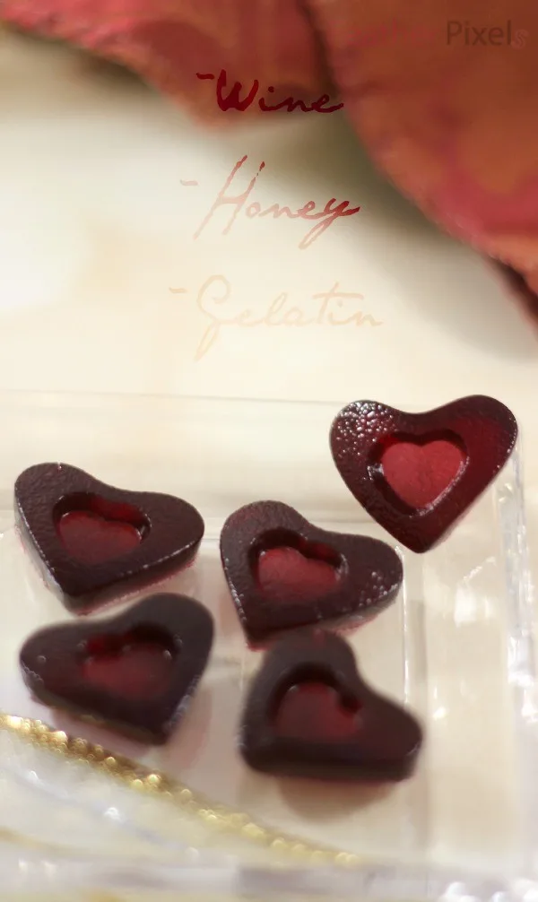 Red wine gummies in heart shapes on a tiny dish