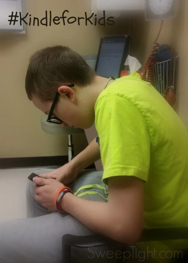 Adam reading on his kindle in a waiting room. 