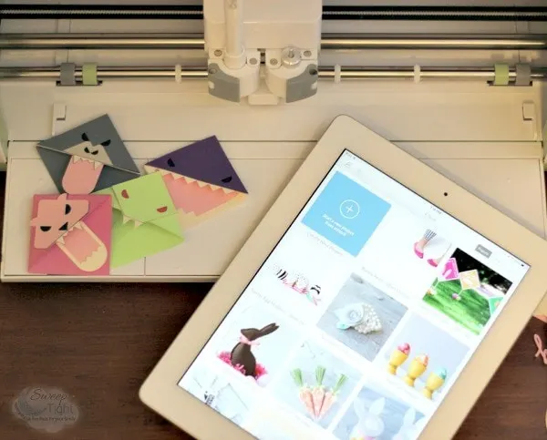 iPad sitting next to the Cricut Explore and animal bookmarks craft. 