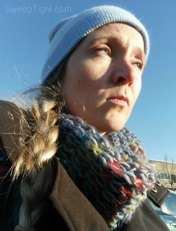 Girl with a winter hat and scarf on with braided hair. 