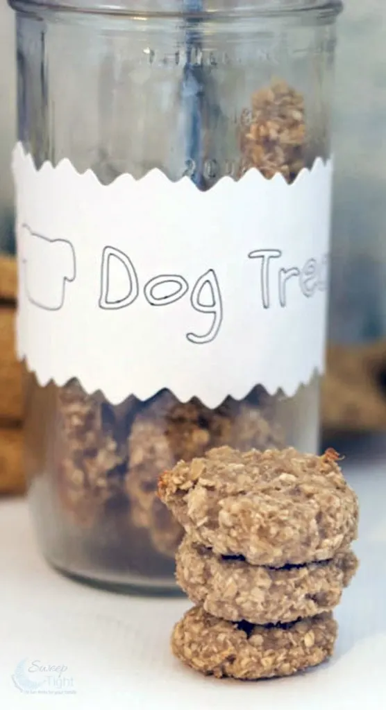 Dog treats stacked in front of a jar full of them. 