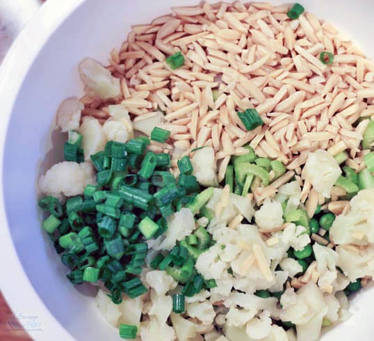 Onion, cauliflower, almonds in a bowl unmixed. 