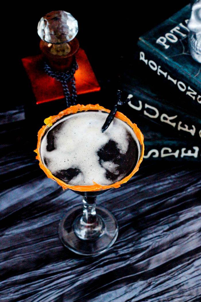 Coffee martini in a glass surrounded by Halloween decor. 
