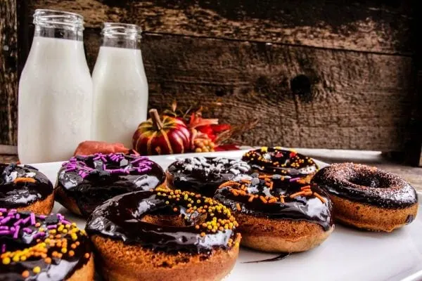 Donuts with dark chocolate glaze and halloween sprinkles.