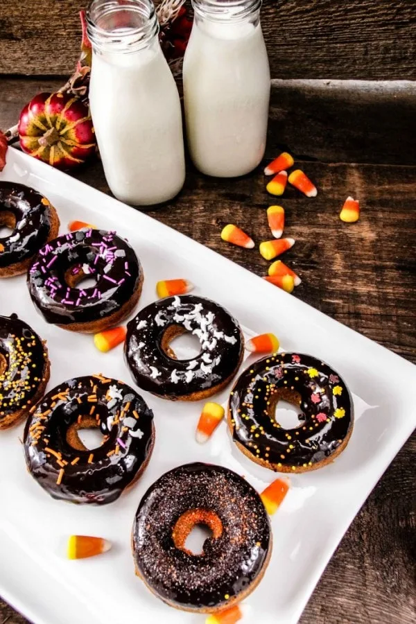 Doughnuts with candy corn and milk on table.