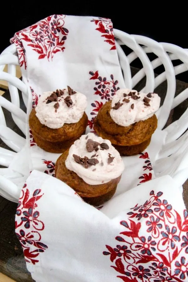 Pumpkin muffins with frosting and chips in a basket. 