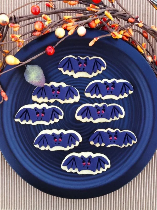 A blue plate full of bat sugar cookies. 