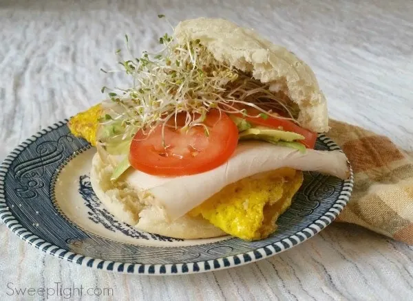 Turkey, eggs, sprouts, tomato, and avocado on an english muffin. 