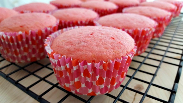 Pink cupcakes on a cooling rack. 