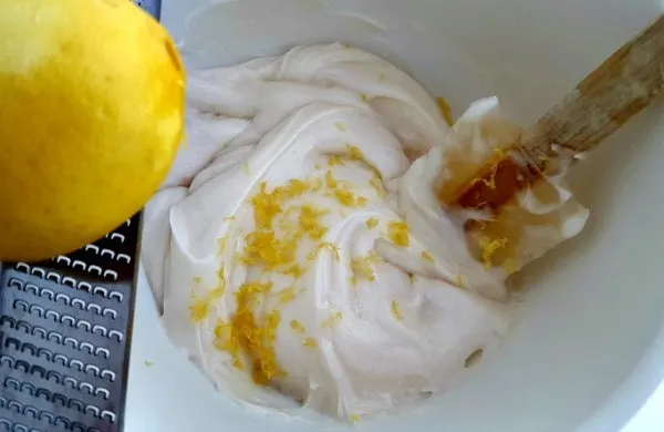 Mixing lemon cream cheese frosting in a bowl. 