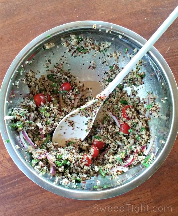 Quinoa, tomatoes, and onion in a bowl. 