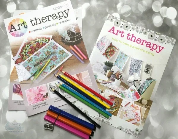 Art therapy coloring books and colored pencils on a table. 