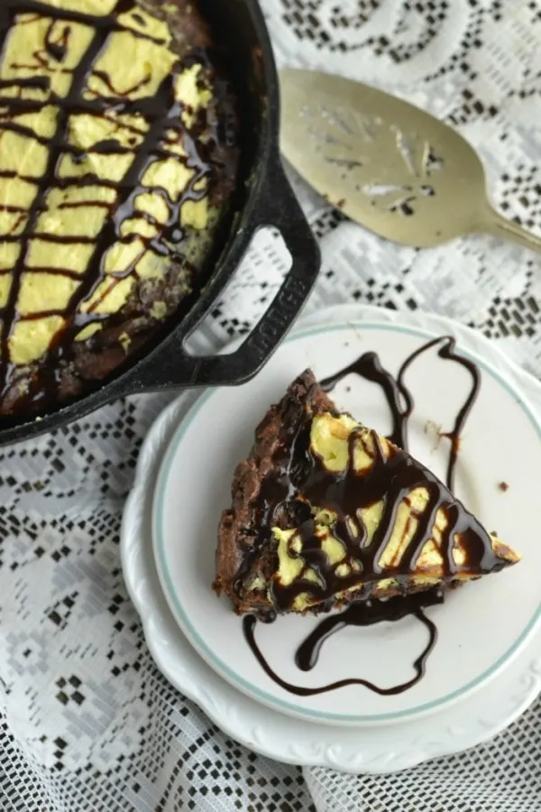 Cookie cake in a skillet and on a plate with a chocolately drizzle. 