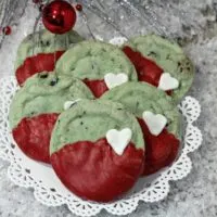 Grinch mint chip cookies on a plate next to Christmas decor.