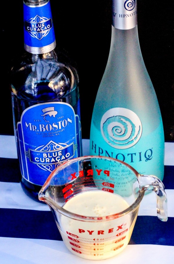 Hypnotiq, Blue Curacao, and egg nog in a measuring cup
