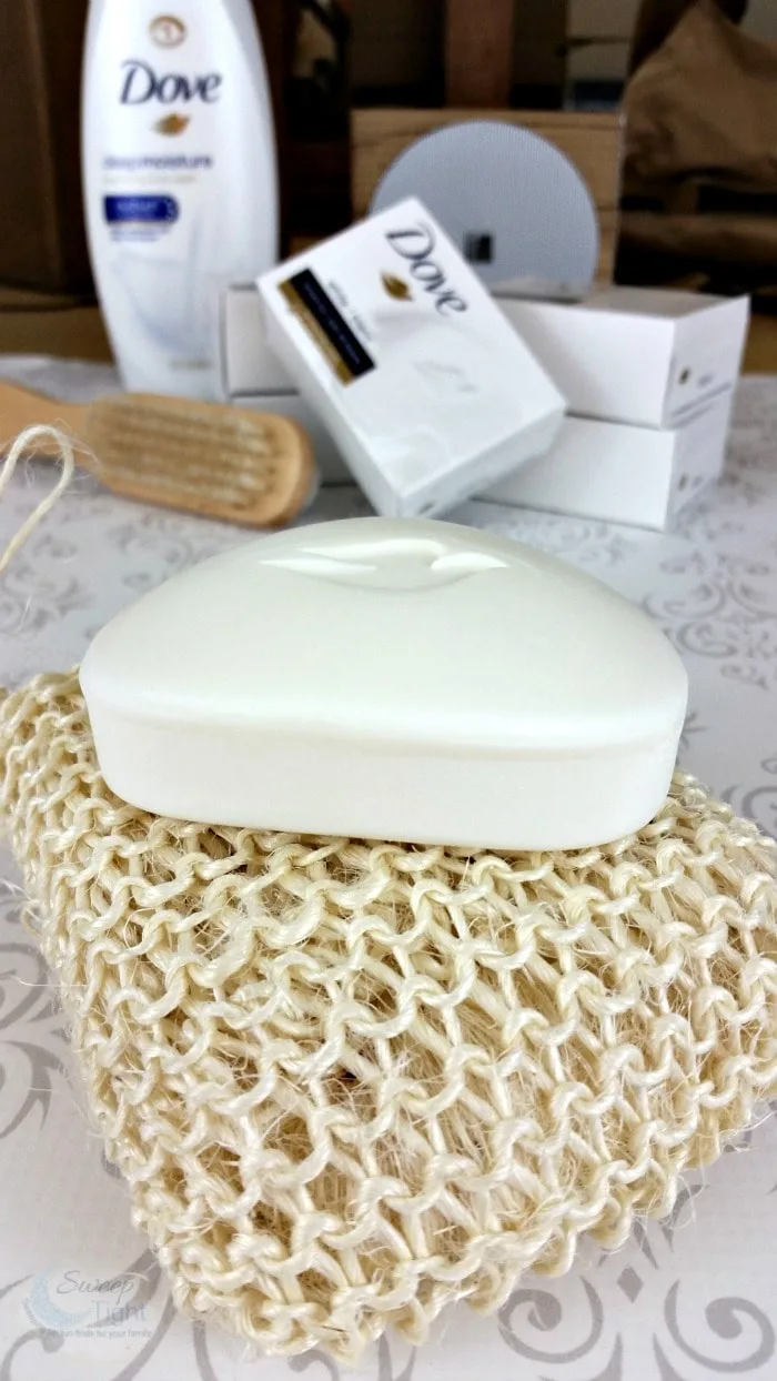 Bar of dove soap on a sponge with more dove products in the background. 