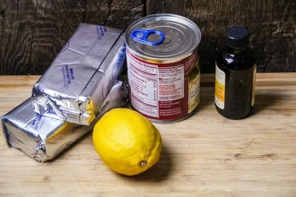 Cream cheese, lemon, and sweetened condensed milk on a table. 