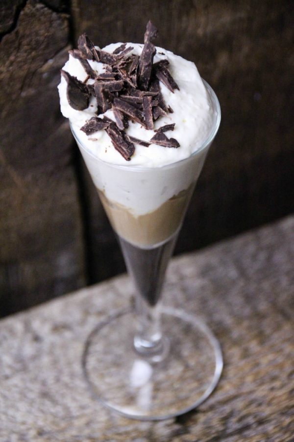 Chocolate cheesecake drink in a glass topped with chocolate shavings. 