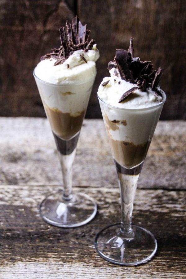 Two glasses of chocolate cheesecake drinks with chocolate shavings on top. 
