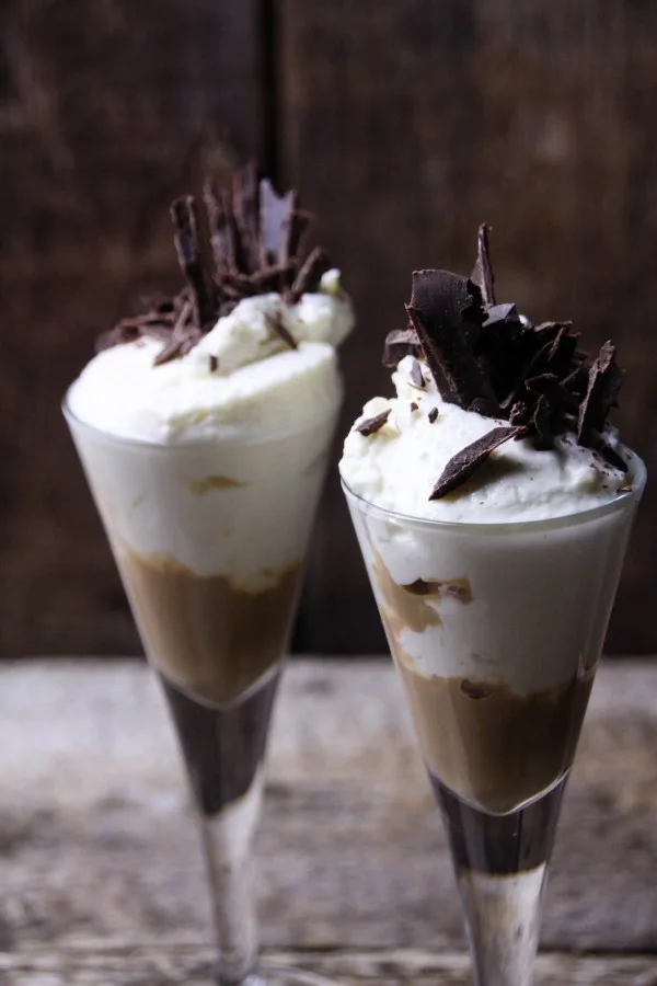 Two cheesecake drinks with chocolate shavings. 