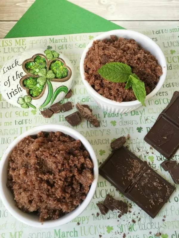 Little dishes of chocolate sugar scrub next to an Irish pin and chocolate shavings. 