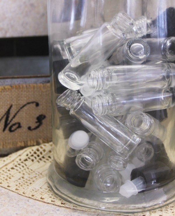 Clear jar filled with smaller empty roller bottles. 