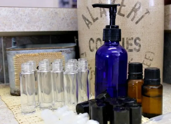 Clear empty bottles, a blue container, and brown glass jars on a table. 