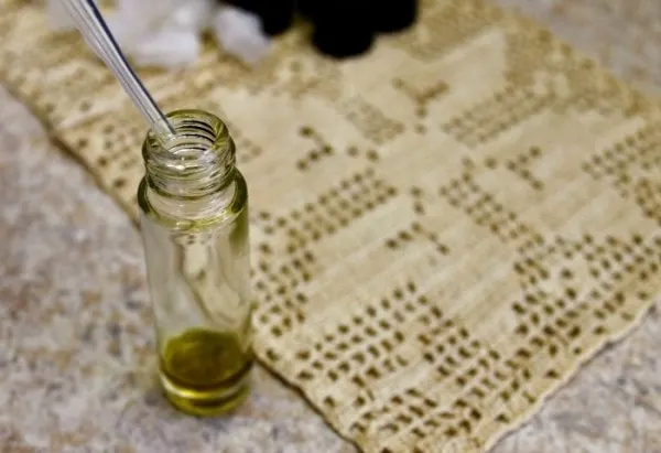 Dropping oil into a roller bottle jar. 
