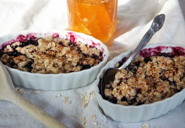 Two dishes with blueberry crumble dessert in them. 