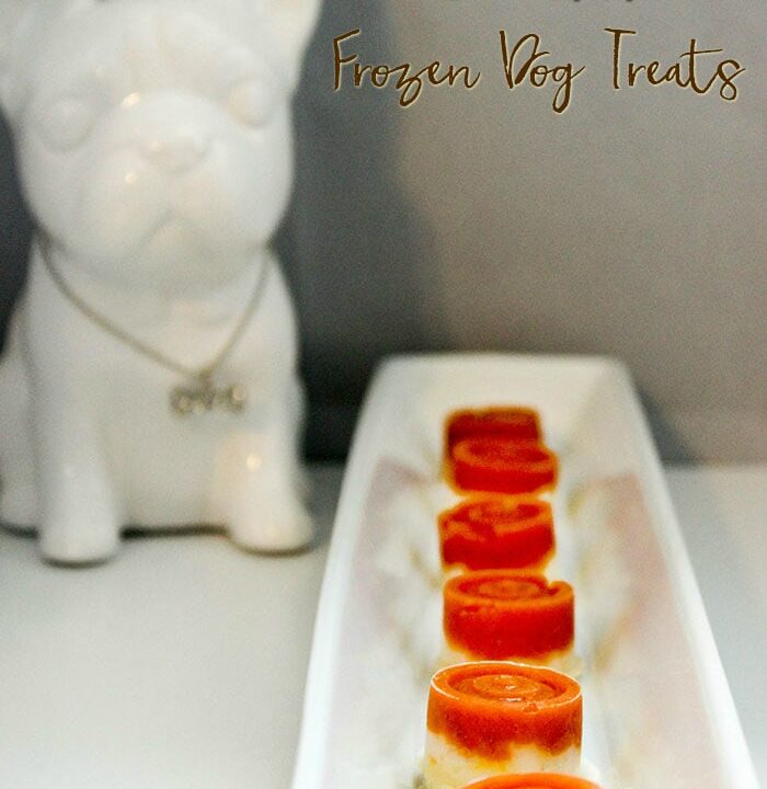 Tiny pumpkin dog treats on a tray next to a white French Bulldog figurine.
