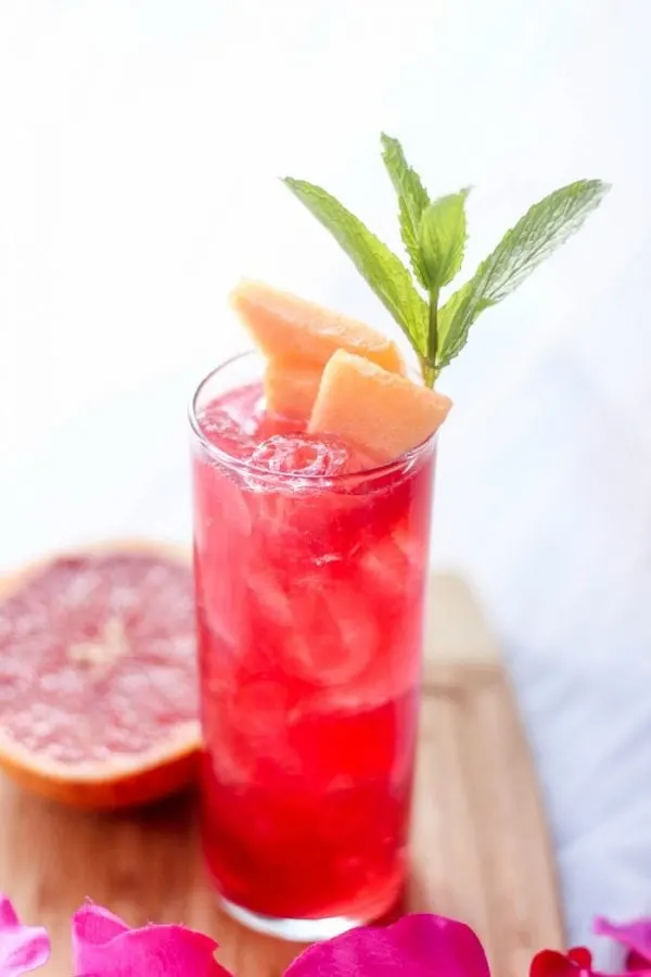 Red grapefruit drink with cantaloupe slices. 