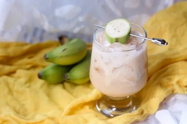 Banana drink in a glass with bananas on the table.