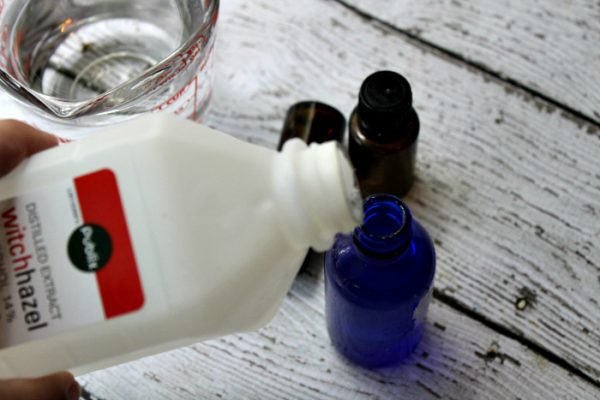 Pouring witch hazel into blue bottle