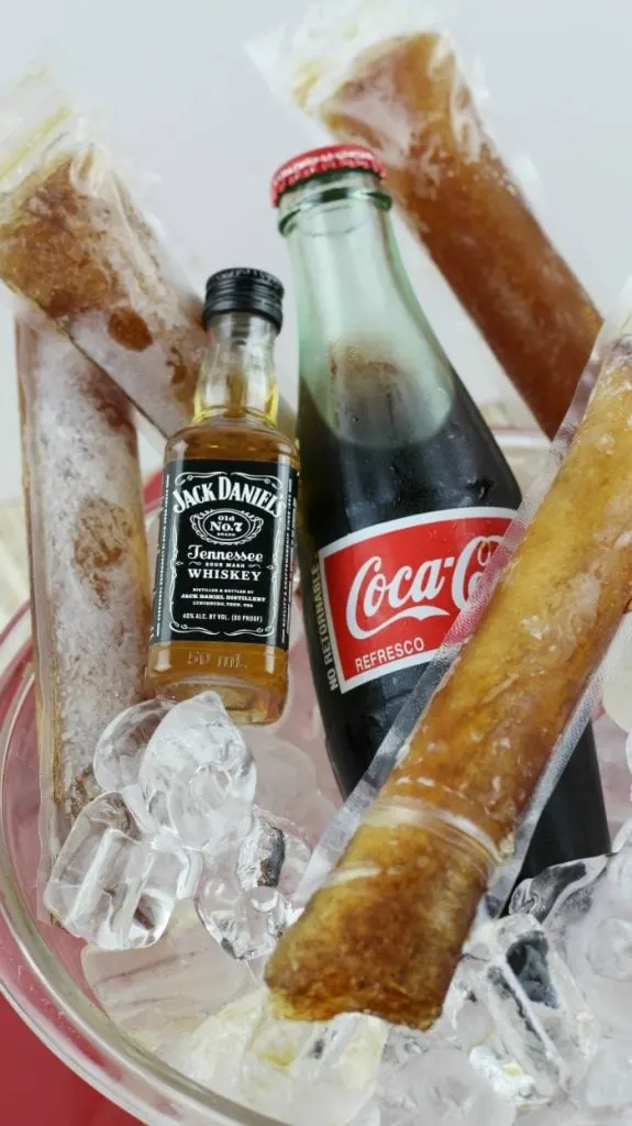 Jack Daniels, Coke, and Frozen coke pops in a bowl of ice.