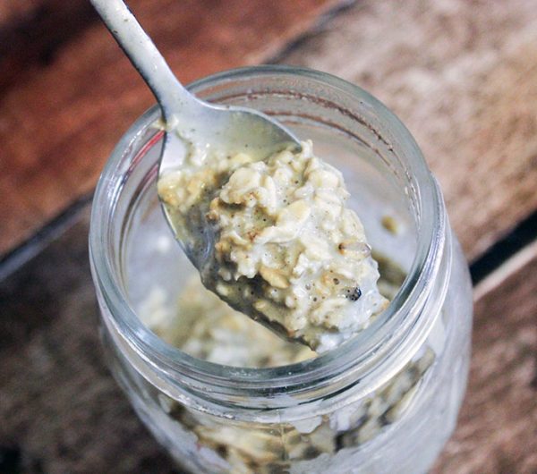 A spoon full of green tea overnight oats above the jar. 