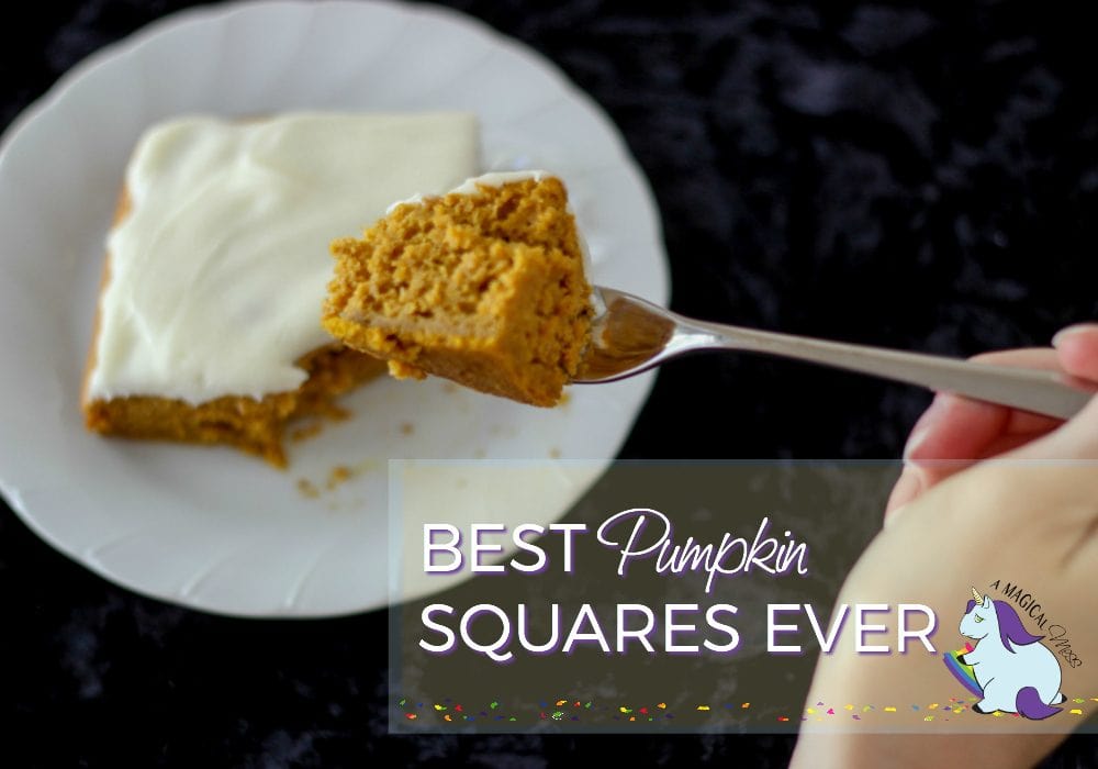 Holding a fork with pumpkin cake on it. A pumpkin square on a plate below it. 