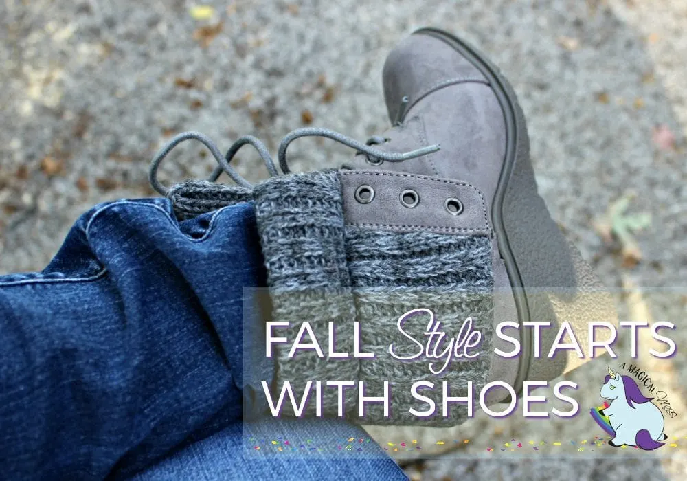 Gray boots on a foot of person wearing jeans.