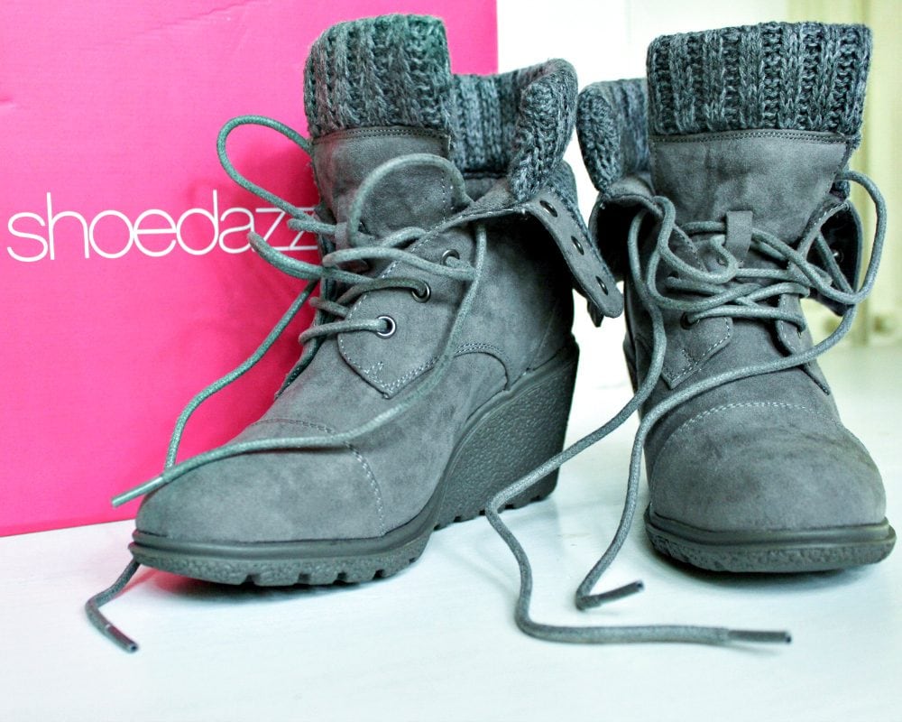 A pair of gray boots next to a pink Shoedazzle box. 