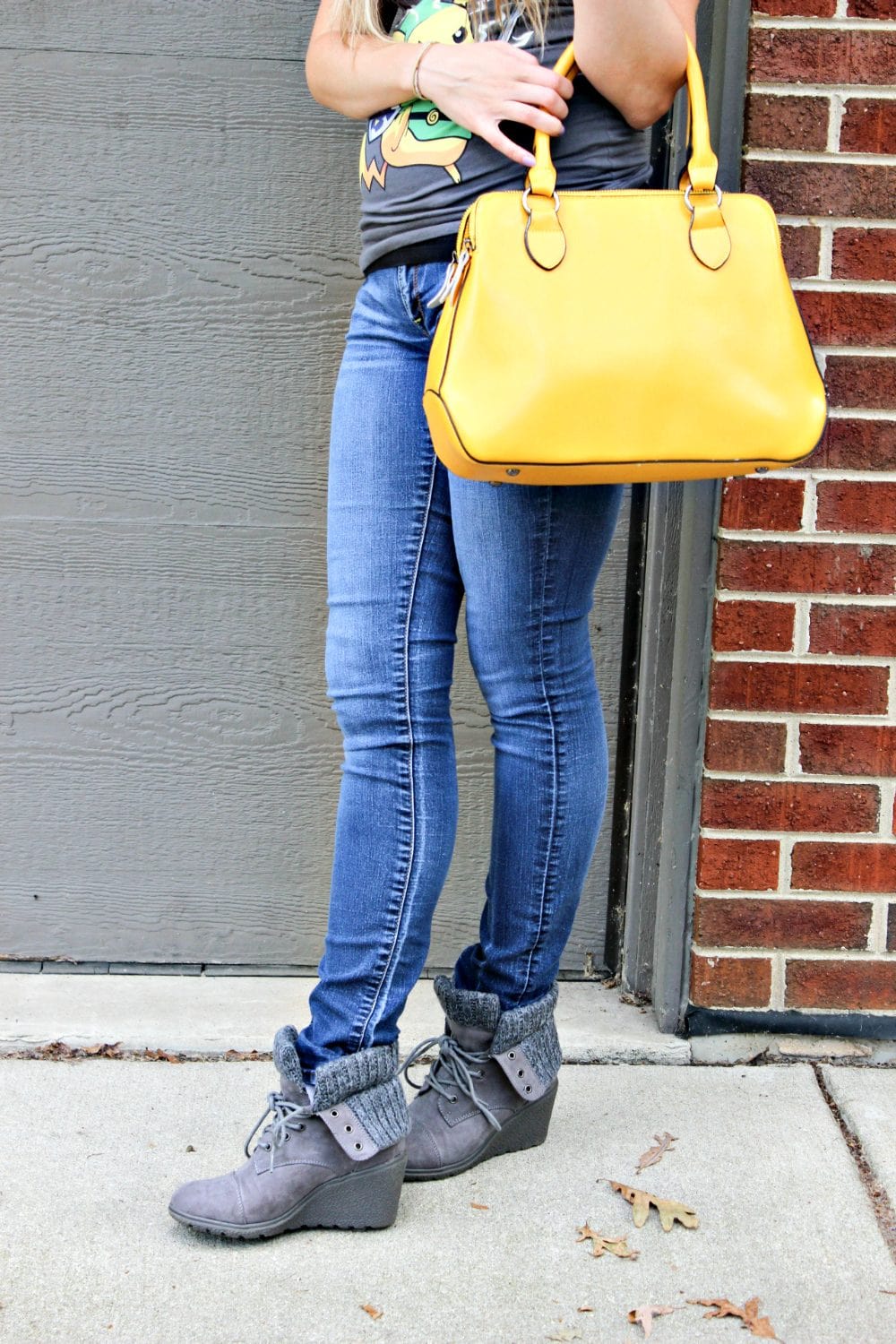 Girl in jeans with a bright yellow purse. 