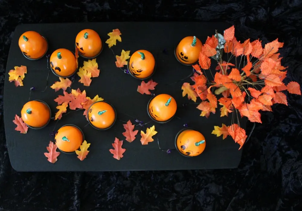 Pumpkin trick or treat game craft on a table with fall decor. 