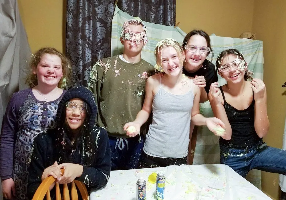 Kids laughing covered in silly string. 