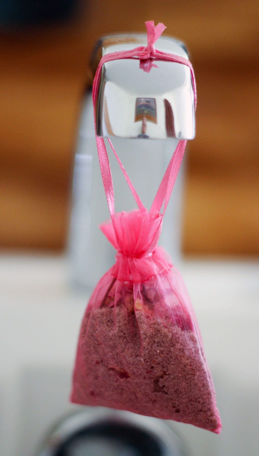 Bath salt in a bag hanging from the faucet